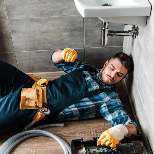 Professional Plumbing Service in UAE technician fixing pipe